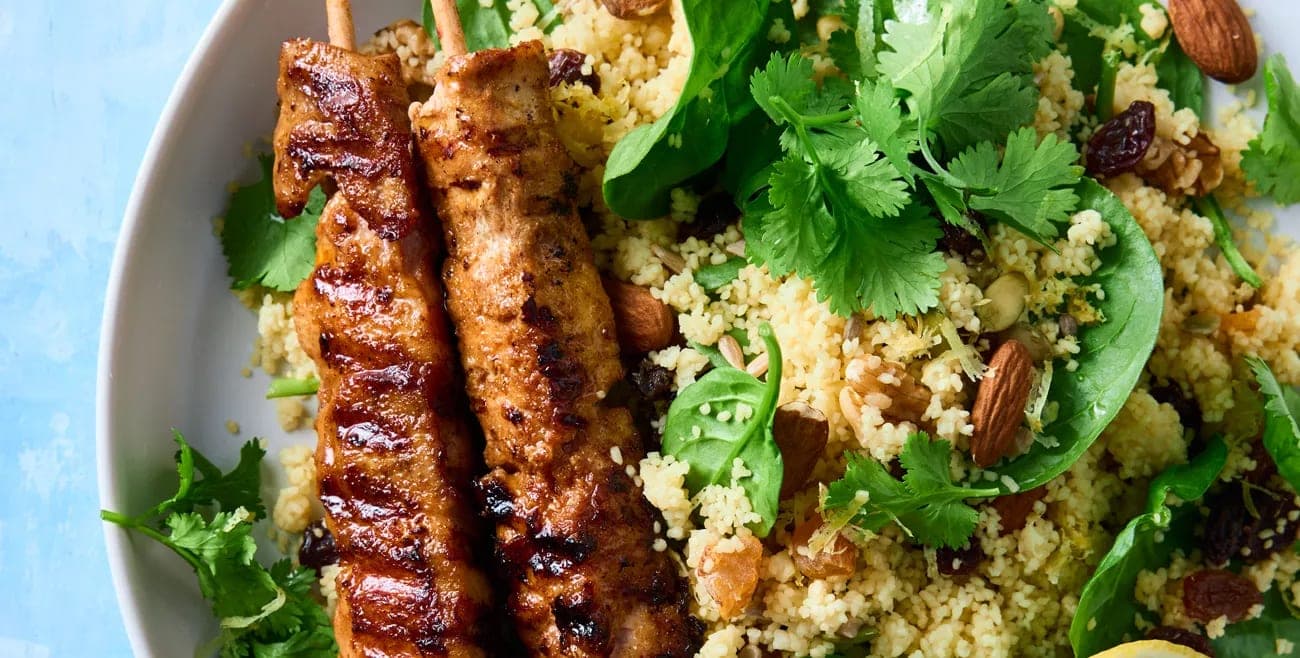 A white plate topped with meat and rice