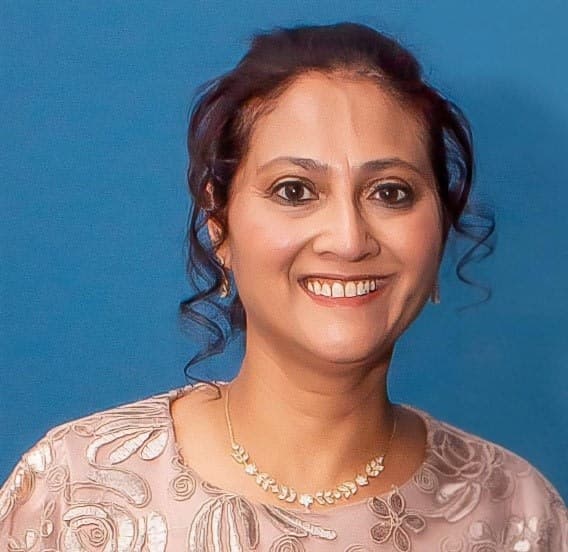 A woman in a dress smiling for the camera