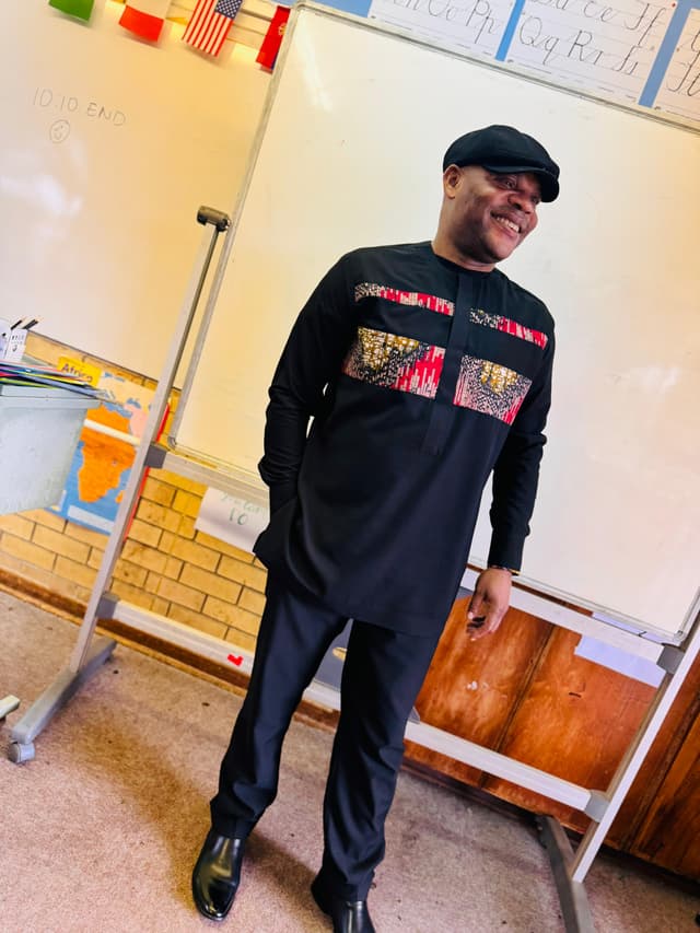 A man standing in front of a whiteboard in a classroom